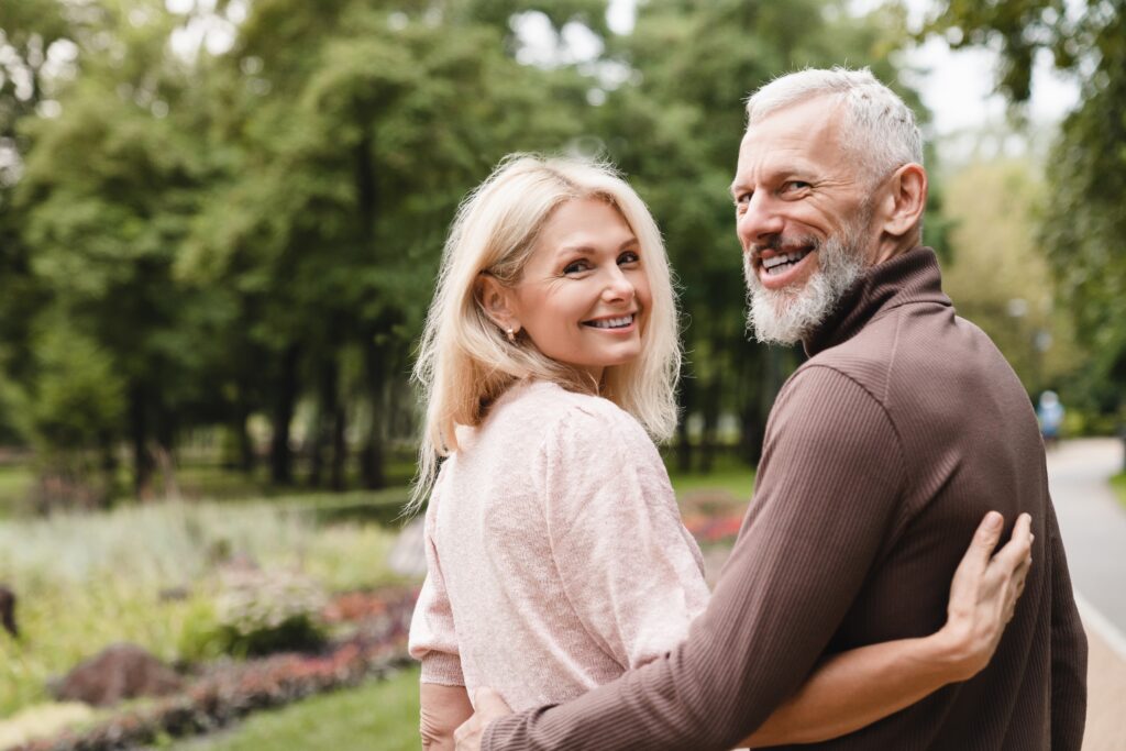 Happy older couple strolling through a garden