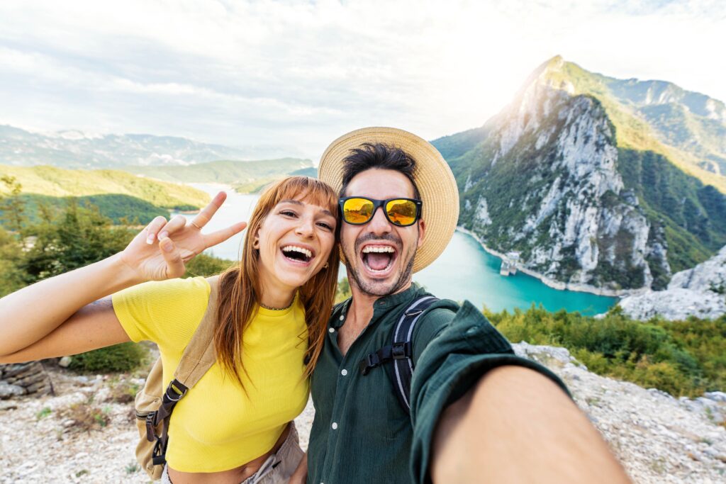 Portrait of a happy couple outside taking a selfie